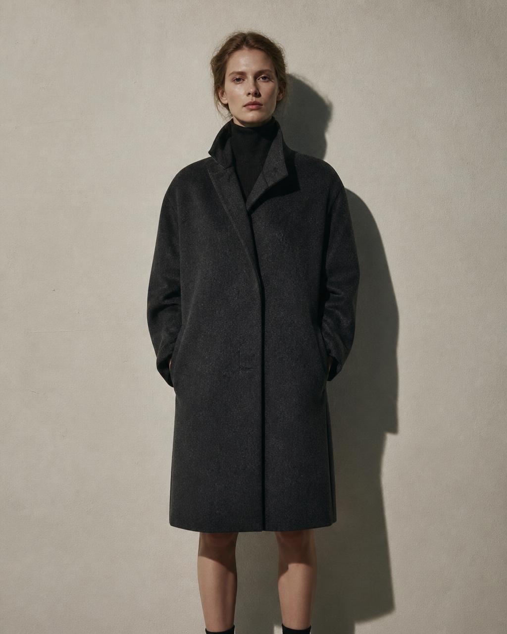 Shoulder of a charcoal wool coat in window light